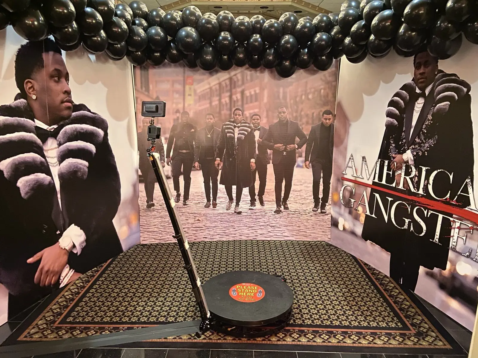 360 photo booth platform and camera arm inside a custom-printed themed enclosure at an event