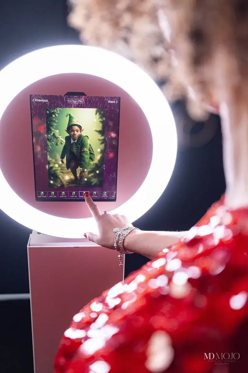 The AI photo booth ring light and tablet, showing the on-screen menu of effects a guest picks from