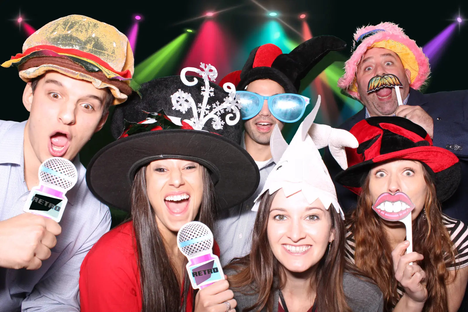 A group of guests with props composited onto a nightclub stage-lighting backdrop